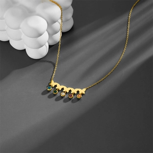 Macro view of gold roman numeral butterfly necklace with five colorful cubic zirconia charms