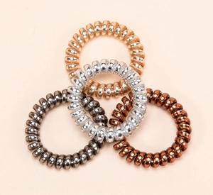 Detail of four metallic spiral hair ties in rose gold, silver, grey, and bronze colors