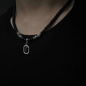 Men's natural stone necklace with black rectangular pendant on a black background