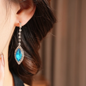Close-up of blue marquise teardrop tassel earring with silver-tone rhinestone setting