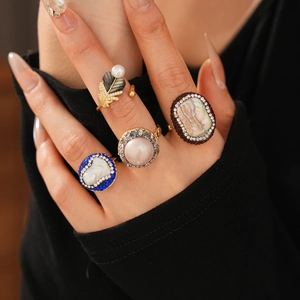Detail of vintage gold plated rings with pearls and colorful zircons on a hand