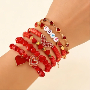 Set de cinco pulseras rojas con corazones y cuentas LOVE en la muñeca de la modelo