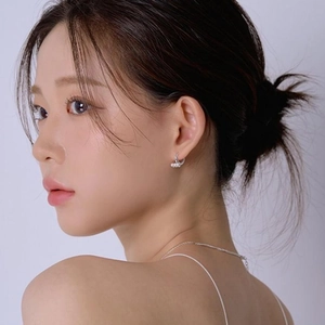 Detail view of small 925 silver pearl hoop earrings worn by a model for a sweet look