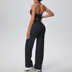 Back view of a black halter yoga set featuring an open-back top and wide-leg sports pants