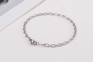 Close-up of a silver geometric oval link chain bracelet with a secure lobster clasp