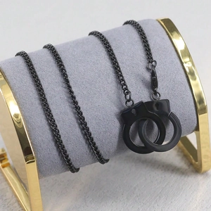Dettaglio della collana con manette nero opaco su un espositore per gioielli in velluto