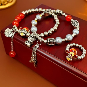 Detailed close-up of dragon pearl bracelets with lucky charms on a red wooden gift box