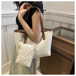 Detail view of large vintage tote bag featuring brown monogram pattern and leather handles