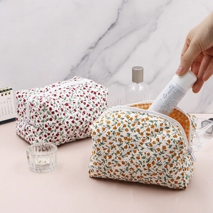 Detail view of quilted floral makeup bags with zipper closure and checkered lining