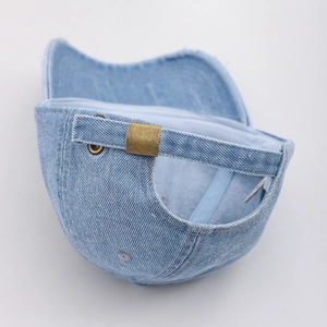 Details der verstellbaren Bronzeschnalle und des gewaschenen Denim-Riemens der Kappe