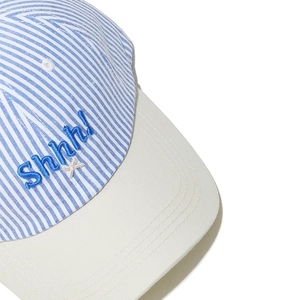 Detailed close-up of blue striped cotton baseball cap with shhh! embroidery design