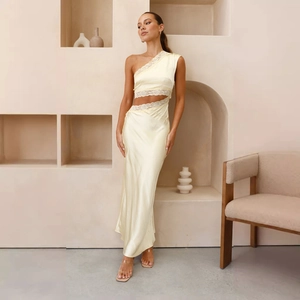 Détail d'une robe en satin jaune clair à une épaule avec dentelle et découpe à la taille