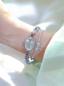 Detail of silver quartz watch with rainbow gemstones and a matching crystal bow bracelet