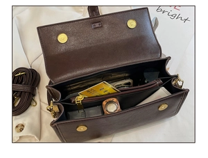 Dettaglio borsa quadrata marrone scuro con tre scomparti e chiusure magnetiche