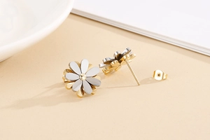 Detailed close-up of daisy stud earrings with two-tone gold and silver petals