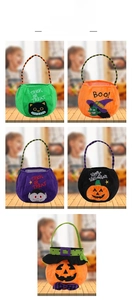 Detail of five Halloween plush candy bags including pumpkin and witch designs with striped handles