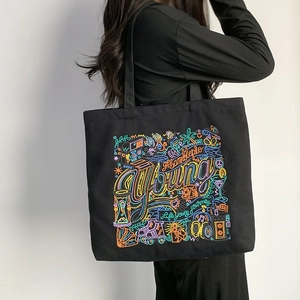 Black canvas tote bag with colorful embroidery patterns and Young Life is a journey quote