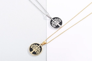 Macro view of gold and silver stainless steel tree of life pendants with black inlay