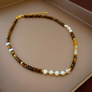 Detailed view of Tiger Eye and pearl beaded necklace with gold lobster clasp