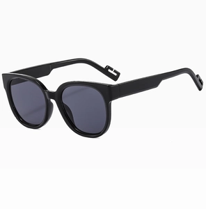 Detail of trendy black sunglasses with dark grey lenses and geometric hollow temple tips