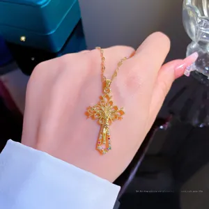 Macro view of gold cross pendant with Jesus relief and colorful stone inlay