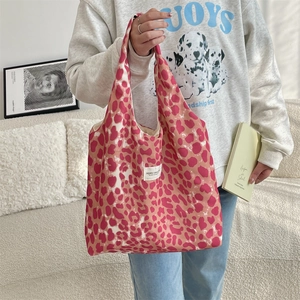 Detailed close-up of pink leopard print canvas tote bag with woven label and sturdy strap
