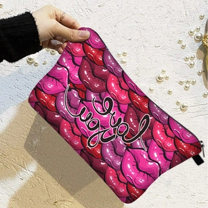 Handheld cosmetic bag with red lip print and Luck text against a pearl background
