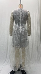 Detail of white floral lace embroidery and sheer mesh fabric on evening gown back