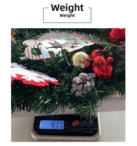 Detailed weight display of a pine needle Christmas wreath with red ornaments and sign