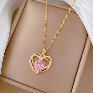 Détail du pendentif cœur en cristal rose sur chaîne dorée dans un coffret cadeau