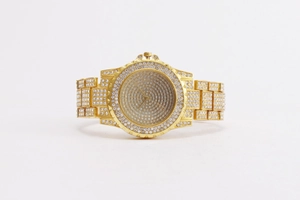 Macro shot of gold tone watch with full rhinestones on bezel, dial and band
