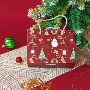 Festive red Merry Christmas paper gift bag with snowman and pine tree illustrations