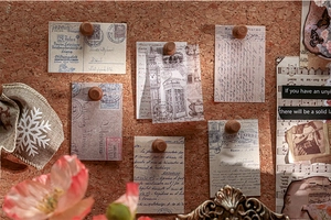 Macro view of vintage floral scrapbooking paper pinned on a rustic cork board
