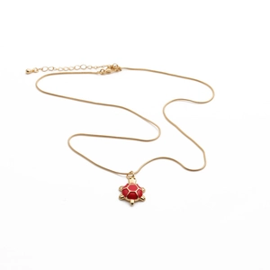 Detail of lobster clasp and extension chain on turtle necklace with red enamel pendant