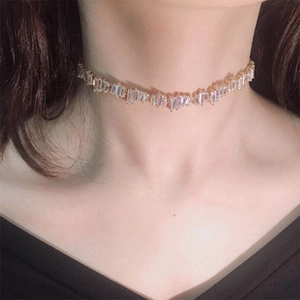 Detailed view of an elegant gold choker necklace with sparkling zircons on a model
