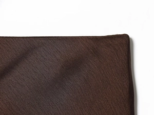 Vue détaillée du tissu en satin marron foncé montrant une texture soyeuse et des coutures