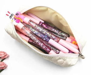 Inside view of white quilted floral pencil case with cute pink cartoon dinosaur pens