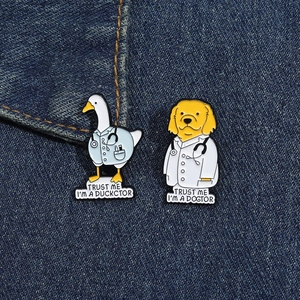 Funny animal doctor enamel pins featuring duck and dog designs on denim background