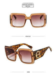 Detail of square brown leopard sunglasses with translucent frames and gold bamboo hinges