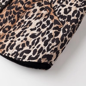 Detail of leopard print quilted jacket showing texture and black stitched hemline