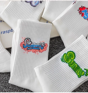 Detail of white cotton athletic socks with colorful graffiti embroidery and soft knit texture