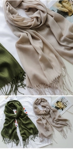 Dettaglio della trama della sciarpa verde oliva e nappe fatte a mano su lino leggero