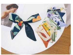 Detail of assorted floral and fruit print ribbons tied in a bow on a white surface