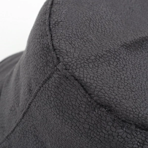Detailed macro view of black fleece fabric texture and neat stitching on a bucket hat