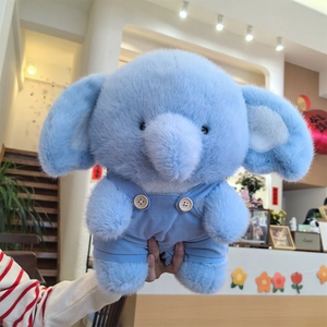 Cute light blue elephant plush toy wearing blue corduroy overalls with wooden buttons