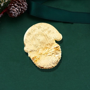 Golden Santa Claus brooch pin back view with textured finish on festive green background