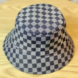 Close-up of gray checkered denim bucket hat on a wooden background for a stylish look