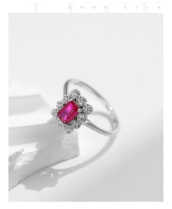 Detailed view of rectangle red gemstone ring with white stones on a geometric stone base
