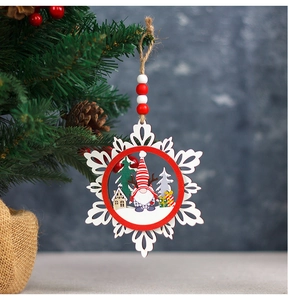 Detail of wooden snowflake ornament with red striped gnome hanging on a Christmas tree