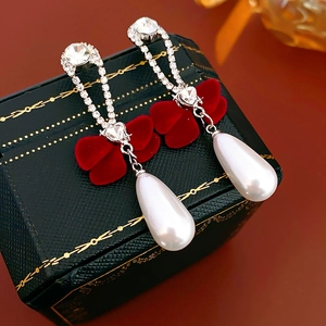 Detail of velvet bow earrings with silver diamond chains and drop pearl pendants